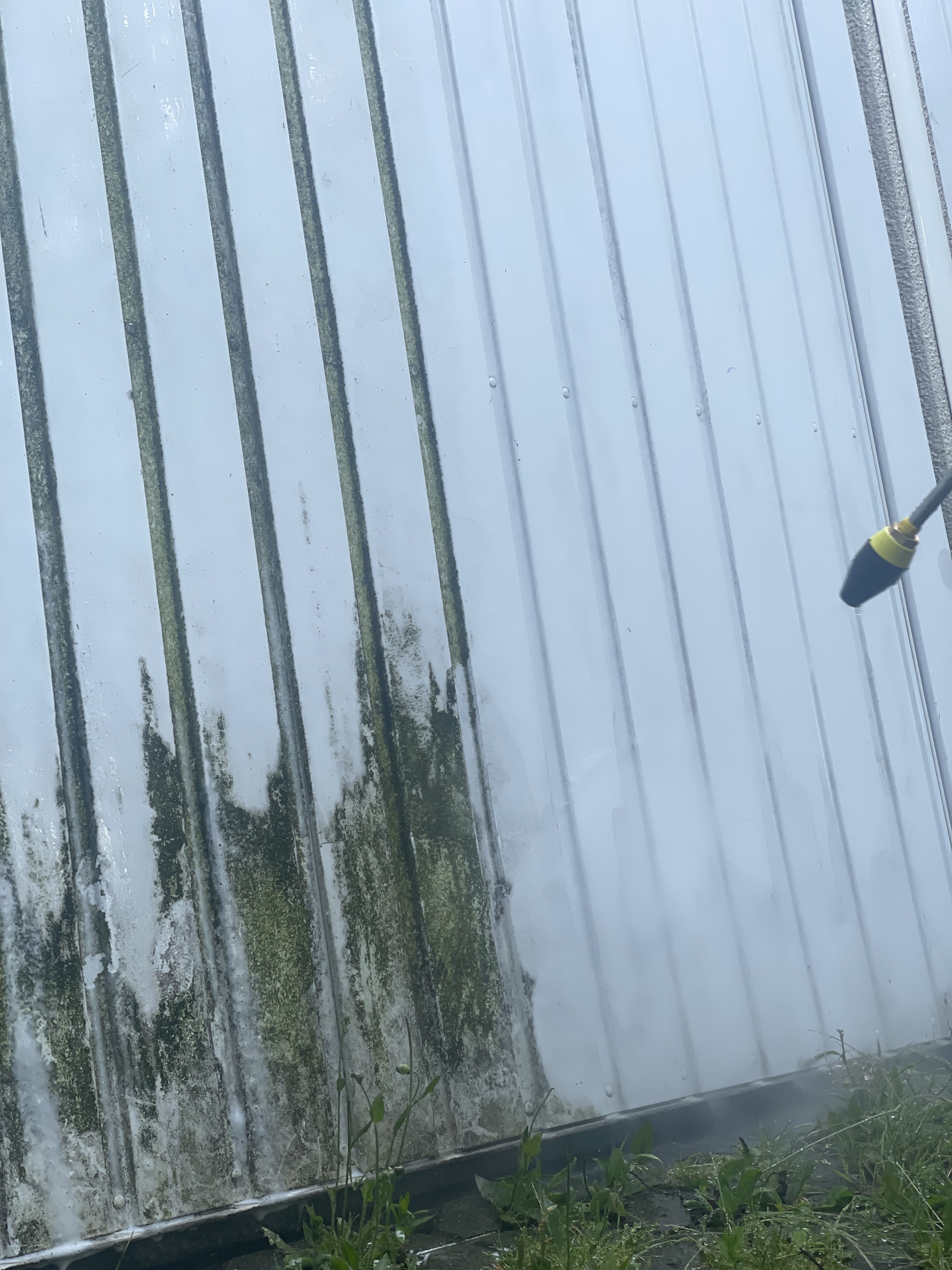 Ein Garagentor während einer Reinigung mit einem Hochdrcukreiniger.